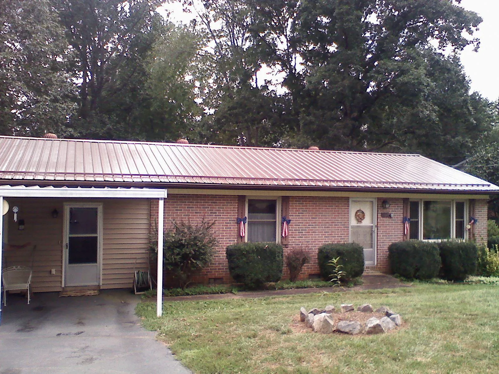 Bronze metal roof and carport on a brick ranch home — Roof Repair work by our crew in Saint Charles